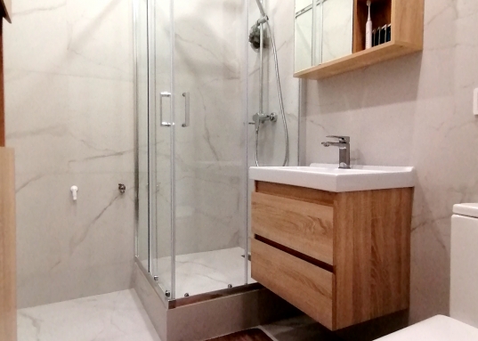 Полы- ламинат, натяжной потолок с точечными светильниками и абажурами, санузел в кафеле, установлена душевая кабина.