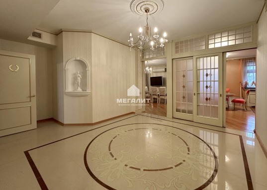 Каждый элемент интерьера подчёркивает изысканный вкус и внимание к деталям:</p><ul><li><p><strong>Полы:</strong> бамбуковый паркет и плитка с системой подогрева — тепло и комфорт в любое время года.</p></li><li><p><strong>Санузлы:</strong> отделка плиткой ручной формовки — эксклюзивная роскошь в каждой детали.</p></li><li><p><strong>Мебель и двери:</strong> массив от итальянских брендов <strong>Turri</strong> и <strong>Buscontti</strong> с элементами декора, покрытыми сусальным золотом.</p></li><li><p><strong>Освещение:</strong> люстры <strong>Swarovski</strong> с кристаллами и полудрагоценными камнями — сияние, достойное королевских покоев.</p></li></ul><h4>Преимущества локации</h4><ul><li><p><strong>Центр власти и бизнеса:</strong> в двух шагах от Госсовета РТ и Кабинета Министров — идеально для тех, кто ценит близость к ключевым государственным и деловым объектам.</p></li><li><p><strong>Респектабельные соседи:</strong> жилой комплекс привлекает людей высокого статуса — бизнесменов и представителей госслужбы.</p></li><li><p><strong>Инфраструктура:</strong> в окружении лучшие рестораны, бутики и культурные учреждения Казани.<br /><br /></p></li></ul><p>Представьте, как вы:</p><ul><li><p>начинаете утро с чашечки кофе на просторной кухне, наслаждаясь тишиной и уютом;</p></li><li><p>принимаете гостей в гостиной, где каждая деталь говорит о вашем безупречном вкусе;</p></li><li><p>возвращаетесь домой после насыщенного дня и паркуетесь в подземном гараже, не беспокоясь о поиске места;</p></li><li><p>проводите вечера в кругу семьи, зная, что живёте в самом сердце города, где всё под рукой.</p></li></ul><p>Эта квартира — не просто недвижимость, а <strong>инвестиция в ваш комфорт и статус</strong>.