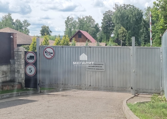 За газоном и деревьями, ухаживает садовник.